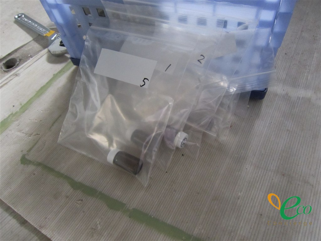 チャック袋に入れたサンプル瓶が並び、それぞれの袋に油性ペンで番号が書かれている様子