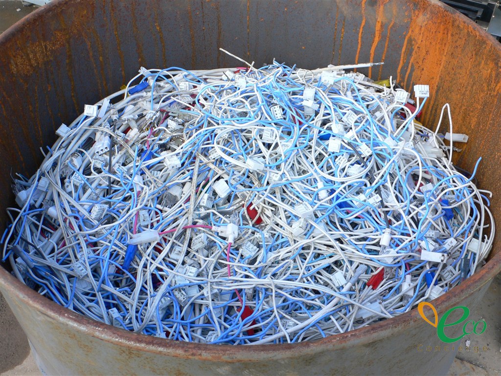 錆びたドラム缶に、コネクタが付いた大量の配線が入っている様子