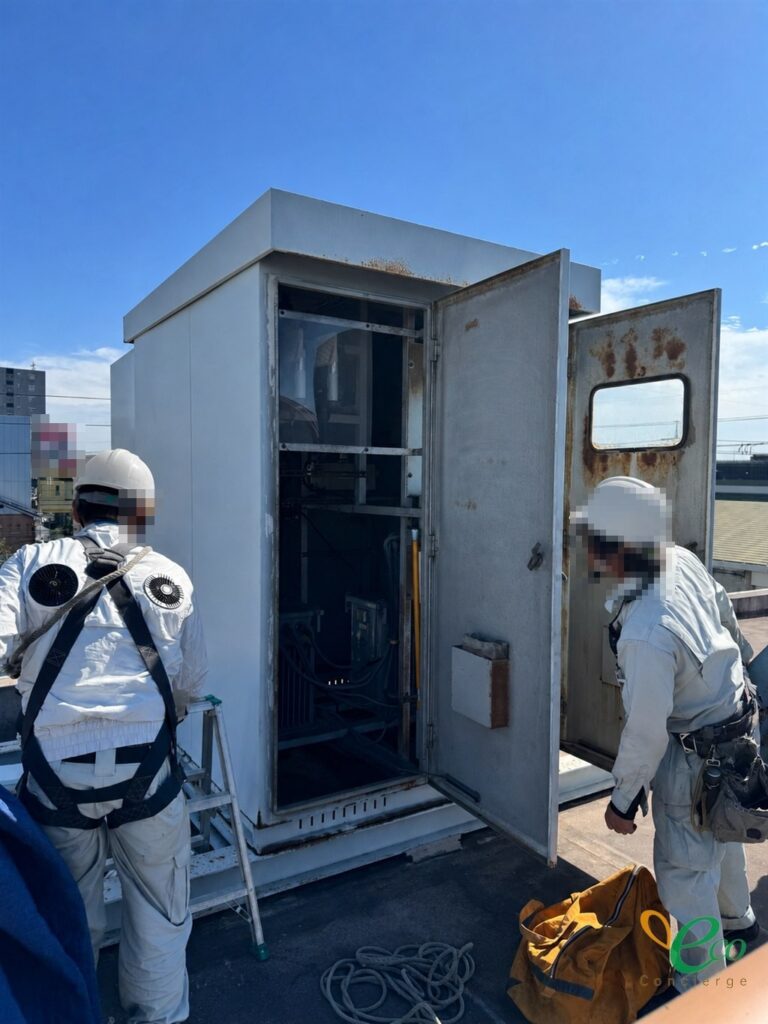 屋上に設置されたキュービクルの扉を開放し、フルハーネスを装着した作業員2名が作業している様子