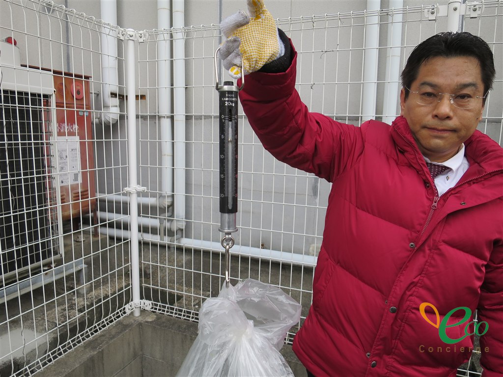 吊り下げ式の秤で、実際に重さを量っている場面です。数量や重量の目安が分かると、確認がその場で進みます。